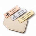 Personalised engraved name badges in rose gold, silver and gold on a cream leather holder