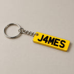 Personalised number plate keychain on a greige surface