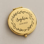 Engraved compact mirror on a greige surface