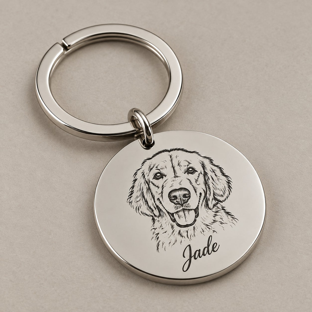 Engraved pet portrait keychain on a greige surface