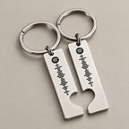 Matching silver Spotify scannable keyrings on a neutral surface