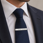 Engraved tie clip worn on a navy tie