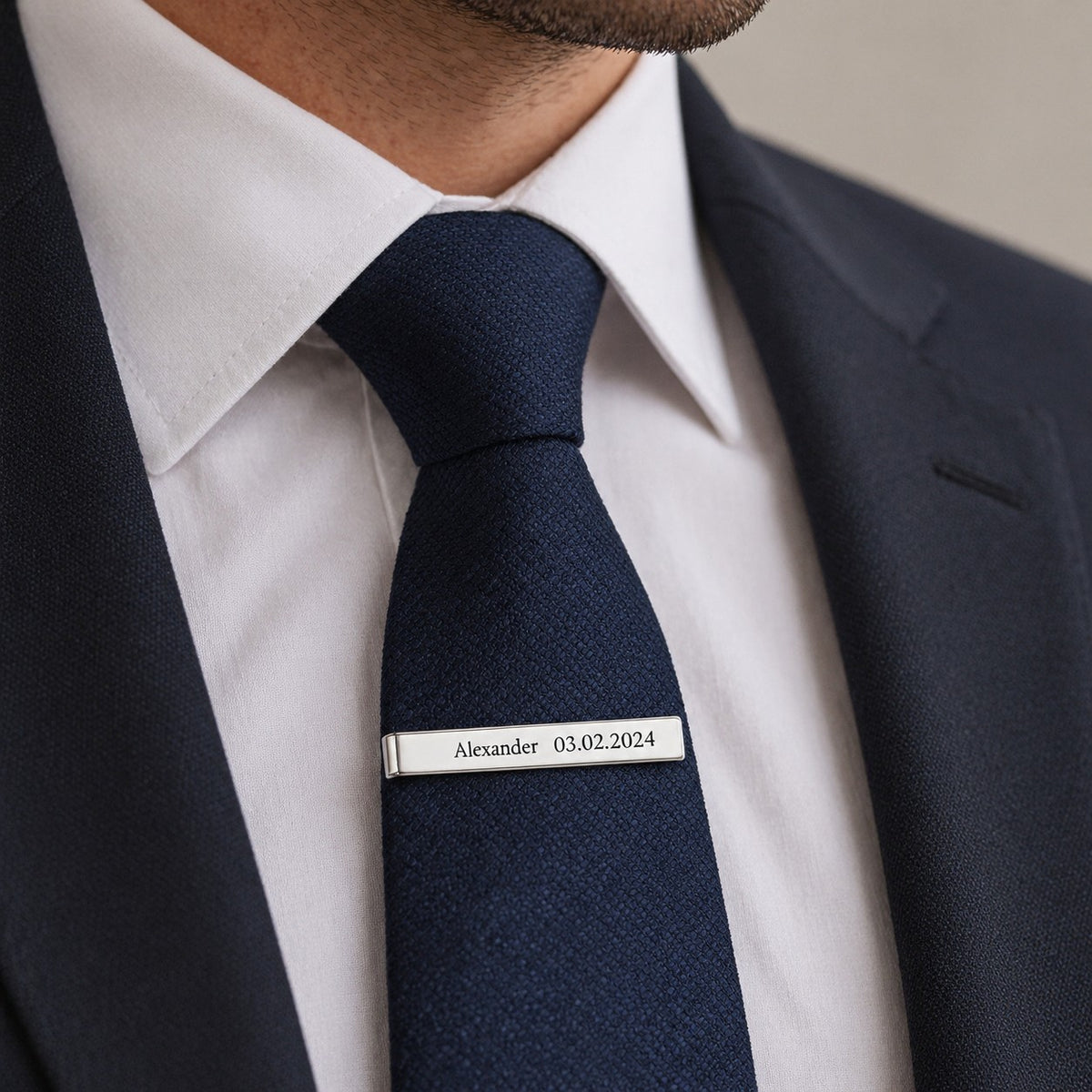 Engraved tie clip worn on a navy tie