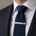 Engraved tie clip worn on a navy tie