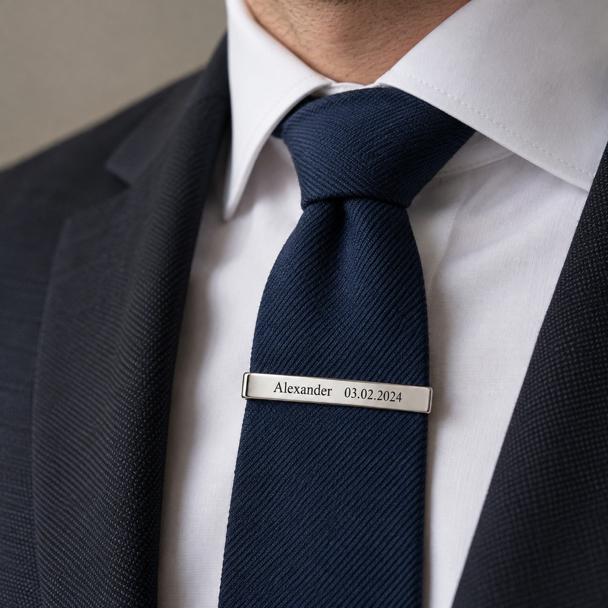 Engraved tie clip worn on a navy tie