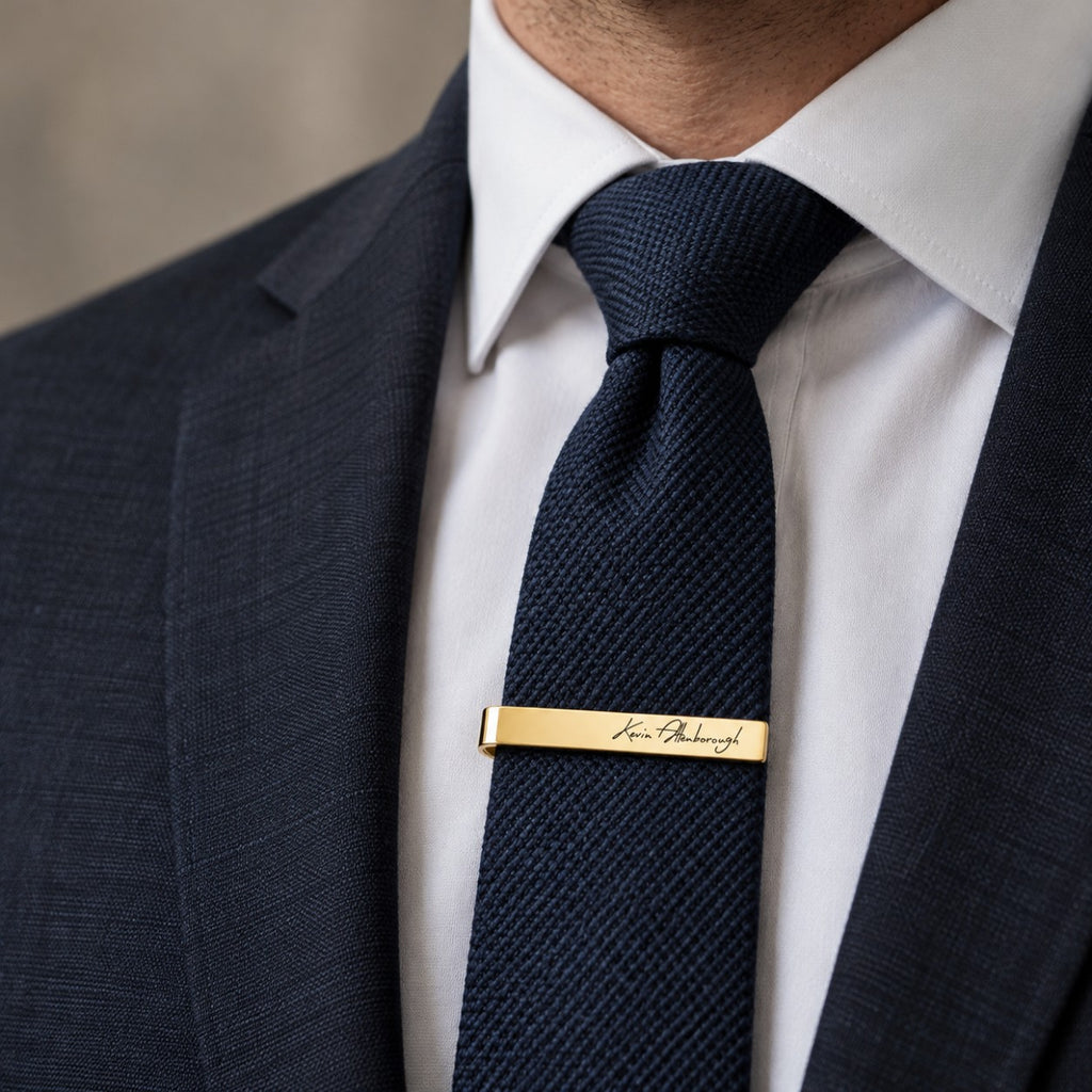 Engraved tie clip worn on a navy tie